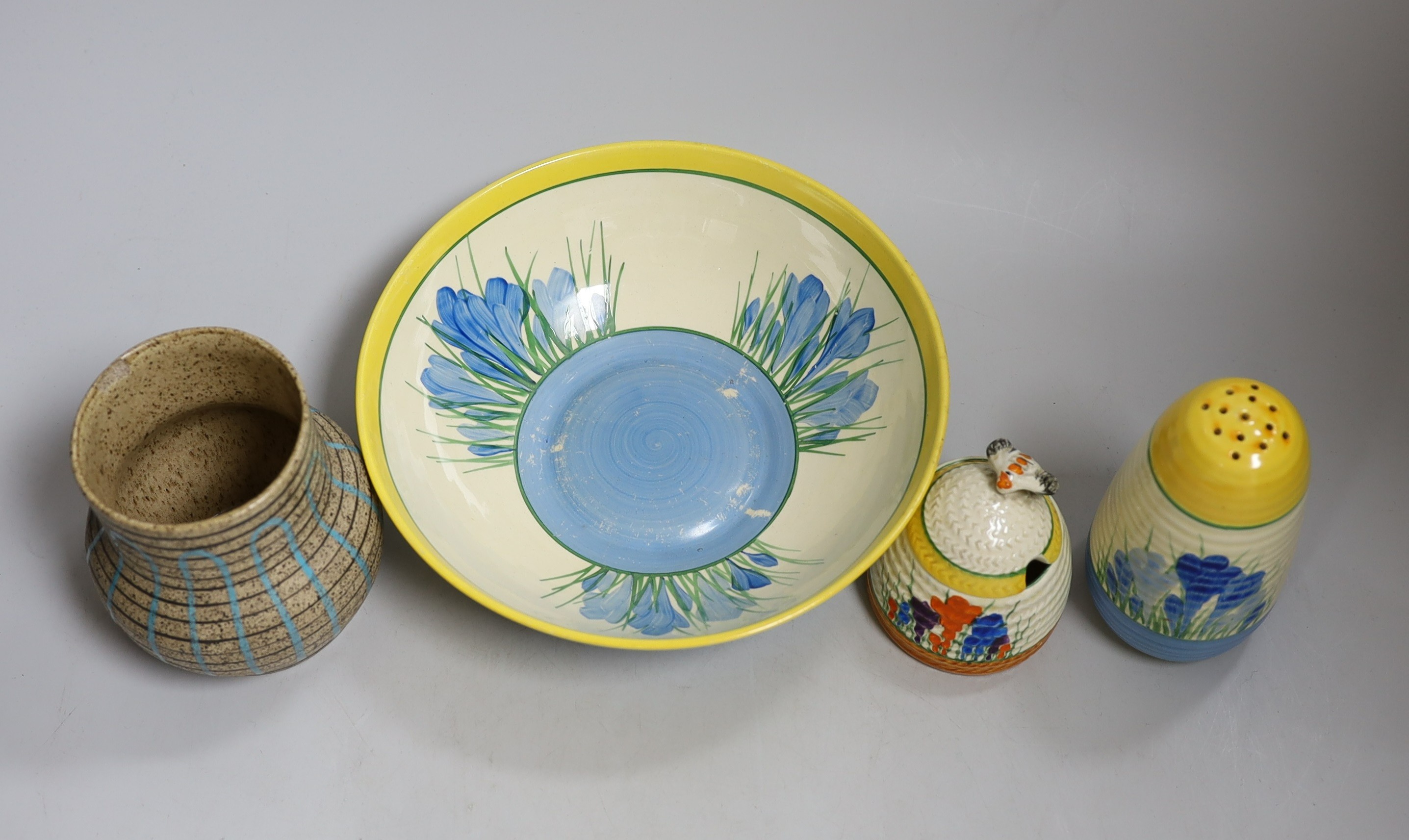 A Clarice Cliff blue crocus caster and bowl, a Clarice Cliff crocus honey pot and a late brown glazed vase. Tallest 18cm